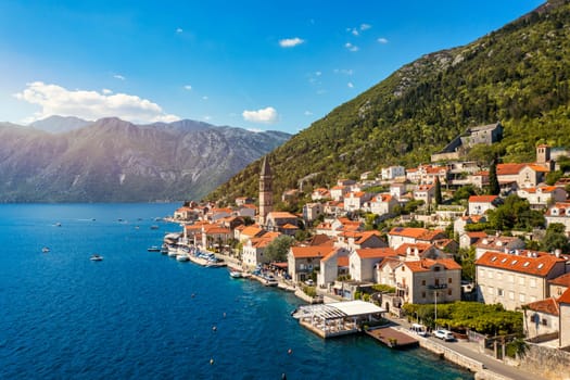 View of the historic town of Perast at famous Bay of Kotor on a beautiful sunny day with blue sky and clouds in summer, Montenegro. Historic city of Perast at Bay of Kotor in summer, Montenegro.
