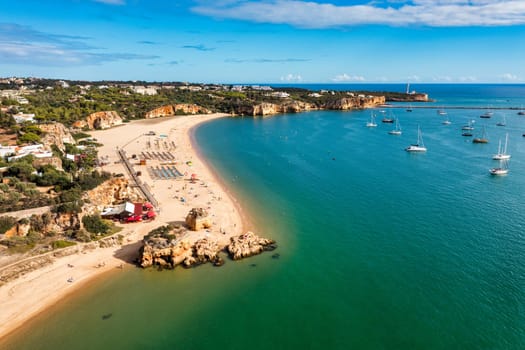 Ferragudo with the Praia Grande (the main beach) and the river Rio Arade, Algarve, Portugal. Beautiful seascape with beach, cave and ocean, Praia Grande beach, Ferragudo, Lagoa, Algarve, Portugal.