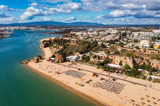 Ferragudo with the Praia Grande (the main beach) and the river Rio Arade, Algarve, Portugal. Beautiful seascape with beach, cave and ocean, Praia Grande beach, Ferragudo, Lagoa, Algarve, Portugal.