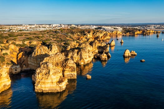 Panoramic view, Ponta da Piedade near Lagos in Algarve, Portugal. Cliff rocks and tourist boat on sea at Ponta da Piedade, Algarve region, Portugal. Ponta da Piedade, Algarve region, Portugal.