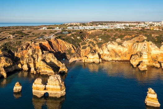 Panoramic view, Ponta da Piedade near Lagos in Algarve, Portugal. Cliff rocks and tourist boat on sea at Ponta da Piedade, Algarve region, Portugal. Ponta da Piedade, Algarve region, Portugal.