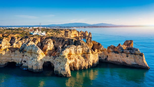 Panoramic view, Ponta da Piedade near Lagos in Algarve, Portugal. Cliff rocks and tourist boat on sea at Ponta da Piedade, Algarve region, Portugal. Ponta da Piedade, Algarve region, Portugal.
