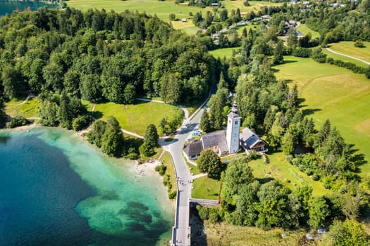 Aerial view of Bohinj lake in Julian Alps. Popular touristic destination in Slovenia. Bohinj Lake, Church of St John the Baptist. Triglav National Park, Julian Alps, Slovenia. 