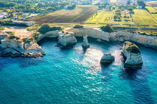 Stunning seascape with cliffs rocky arch and stacks (Faraglioni) at Torre Sant Andrea, Salento coast, Puglia region, Italy. Beautiful cliffs and sea stacks of Sant'Andrea, Salento, Apulia, Italy