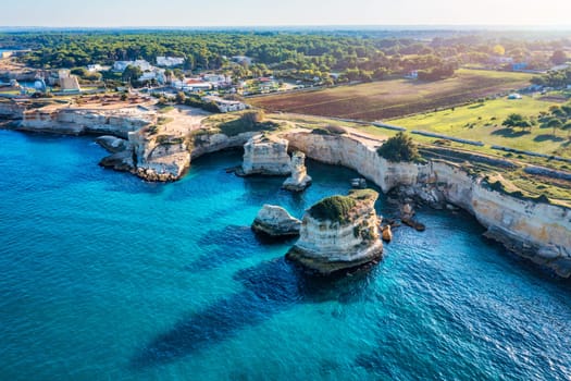 Stunning seascape with cliffs rocky arch and stacks (Faraglioni) at Torre Sant Andrea, Salento coast, Puglia region, Italy. Beautiful cliffs and sea stacks of Sant'Andrea, Salento, Apulia, Italy
