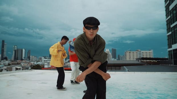 Professional asian dancer practice B boy dance while multicultural friends dancing at roof top. Young modern dancing group doing hip hop movement. Style,fashion,action. Outdoor sport 2024. Endeavor.