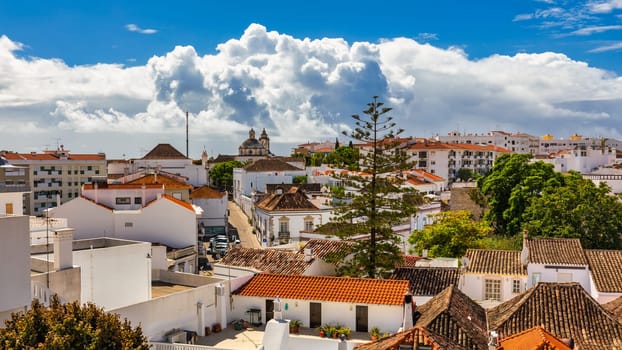 View of the city of Tavira, charming architecture of Tavira, Algarve, Portugal. Santiago of Tavira church in the old town of the beautiful city of Tavira in a sunny day. Algarve region, Portugal