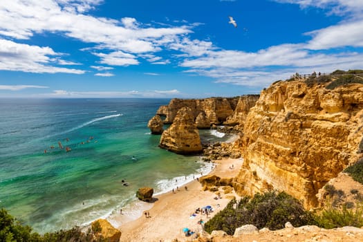 Praia da Marinha, beautiful beach Marinha in Algarve, Portugal. Navy Beach (Praia da Marinha) with flying seagulls over the beach, located on the Atlantic coast in Lagoa Municipality, Algarve.