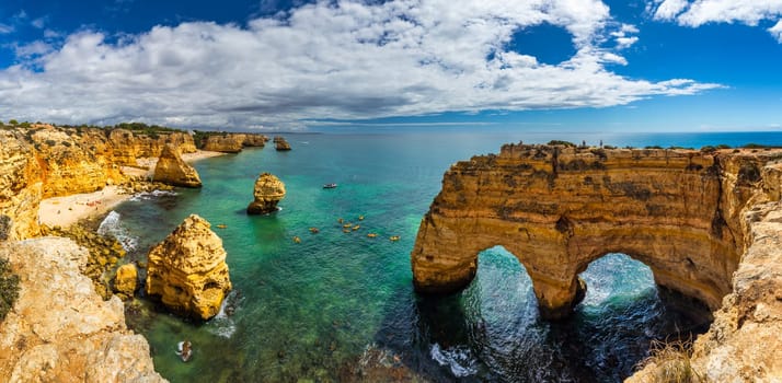 Natural caves at Marinha beach, Algarve Portugal. Rock cliff arches on Marinha beach and turquoise sea water on coast of Portugal in Algarve region. 