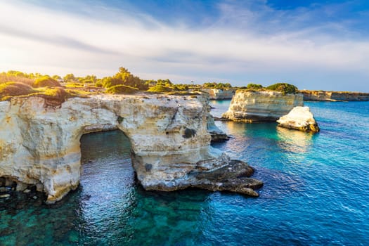 Stunning seascape with cliffs rocky arch and stacks (Faraglioni) at Torre Sant Andrea, Salento coast, Puglia region, Italy. Beautiful cliffs and sea stacks of Sant'Andrea, Salento, Apulia, Italy