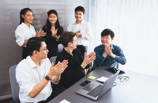 Diverse group of office worker and employee applauding, happily collaborate on strategic business marketing planning. Teamwork and positive attitude create productive and supportive workplace. Prudent