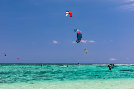 Kite surfers in the waters of Indian Ocean, Mauritius. Kite surfing in the clear waters of the Indian Ocean in Le Morne beach, Mauritius. Best Kite surfing experience at Mauritius island.