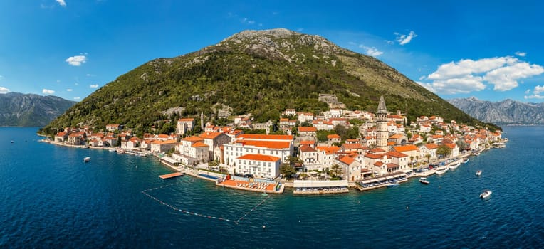 View of the historic town of Perast at famous Bay of Kotor on a beautiful sunny day with blue sky and clouds in summer, Montenegro. Historic city of Perast at Bay of Kotor in summer, Montenegro.