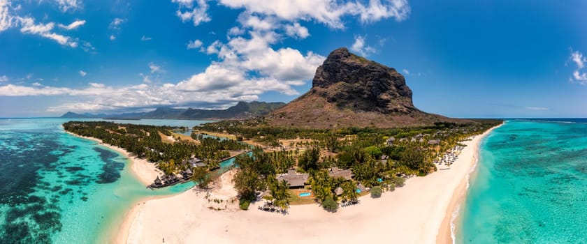 Beach with palm trees and umbrellas on Le morne beach in Mauriutius. Luxury tropical beach and Le Morne mountain in Mauritius. Le Morne beach with palm trees, white sand and luxury resorts, Mauritius