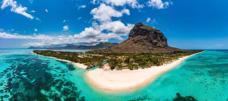 Beach with palm trees and umbrellas on Le morne beach in Mauriutius. Luxury tropical beach and Le Morne mountain in Mauritius. Le Morne beach with palm trees, white sand and luxury resorts, Mauritius