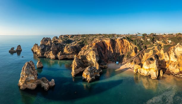 Camilo beach (Praia do Camilo) in Lagos, Algarve, Portugal. Wooden footbridge to the beach Praia do Camilo, Portugal. Picturesque view of Praia do Camilo beach in Lagos, Algarve region, Portugal.