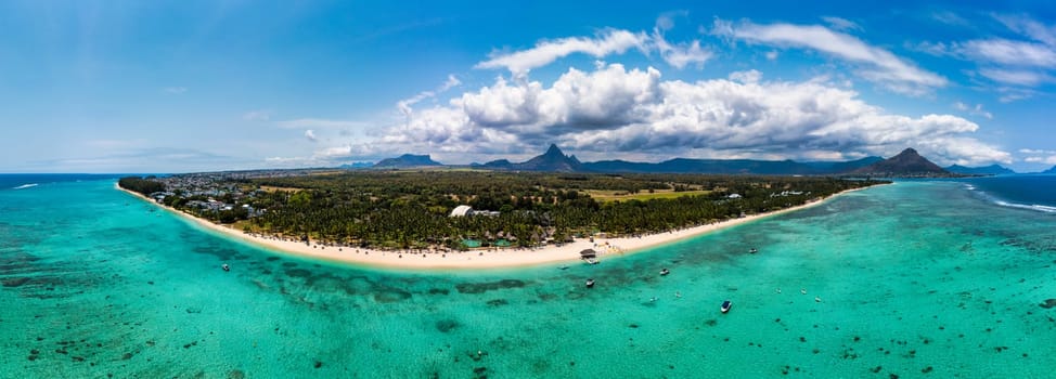 Beach of Flic en Flac with beautiful peaks in the background, Mauritius. Beautiful Mauritius Island with gorgeous beach Flic en Flac, aerial view from drone. Flic en Flac Beach, Mauritius Island.