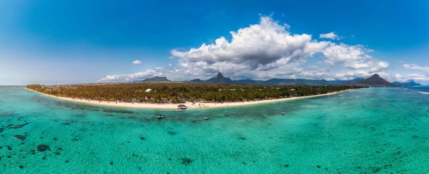 Beach of Flic en Flac with beautiful peaks in the background, Mauritius. Beautiful Mauritius Island with gorgeous beach Flic en Flac, aerial view from drone. Flic en Flac Beach, Mauritius Island.