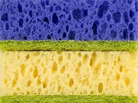 Close up of horizontally stacked sponges in different colors. Sponges are arranged in the following order: blue, green, and yellow green