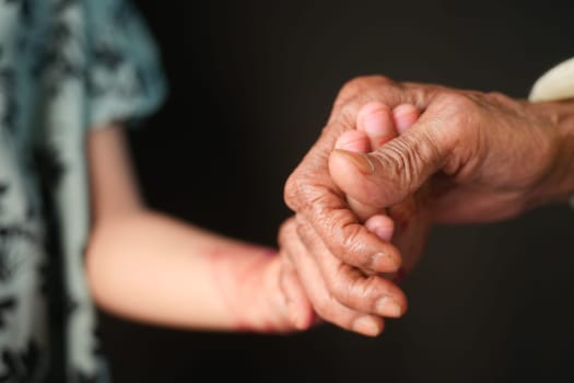 little girl holding hand of her grandmother hand .