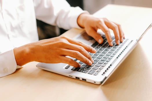 Businessman hand typing on computer keyboard of a laptop computer in office. Business and finance concept. uds