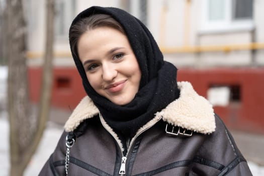 portrait of a young beautiful woman in a headscarf in winter outside