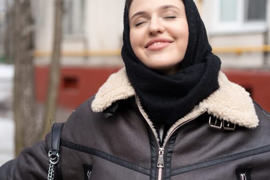 portrait of a young beautiful woman in a headscarf in winter outside