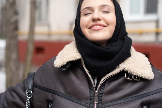 portrait of a young beautiful woman in a headscarf in winter outside