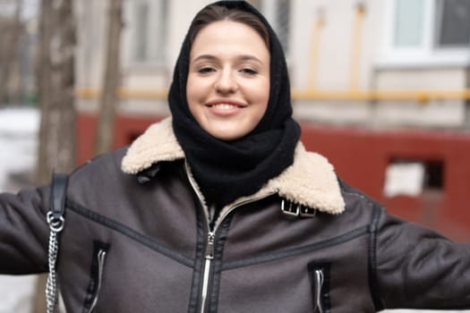 portrait of a young beautiful woman in a headscarf in winter outside