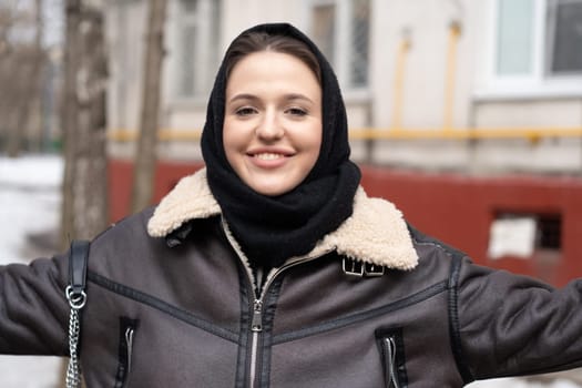 portrait of a young beautiful woman in a headscarf in winter outside