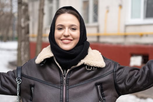 portrait of a young beautiful woman in a headscarf in winter outside