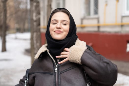 portrait of a young beautiful woman in a headscarf in winter outside