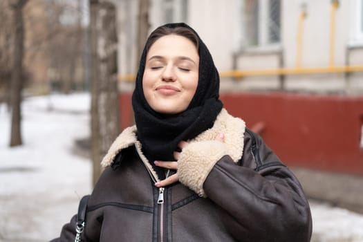 portrait of a young beautiful woman in a headscarf in winter outside