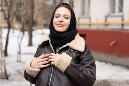 portrait of a young beautiful woman in a headscarf in winter outside