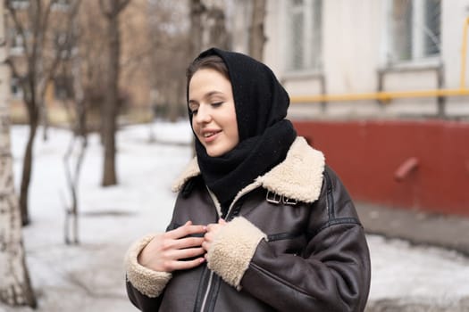 portrait of a young beautiful woman in a headscarf in winter outside