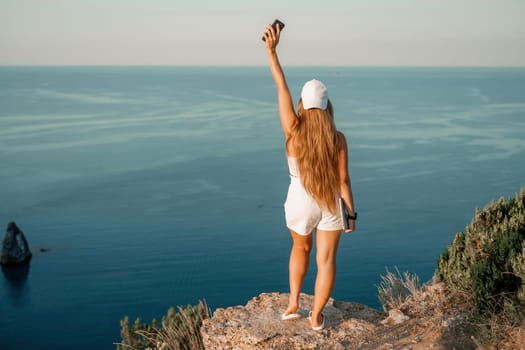 Portrait of a happy woman in a cap with long hair against the sea.