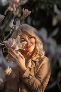 A woman is holding a magnolia flower in her hand and standing in front of a tree. Concept of serenity and beauty, as the woman is surrounded by nature and the flower adds a touch of color