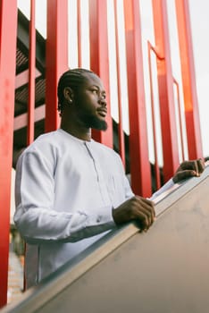 Close up portrait of a happy african american man smiling wearing ethnic dashiki clothes outdoor in summer street wall. Millennial generation student and youth. Copy space.