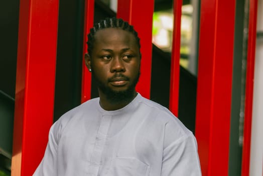 Cheerful male tourist portrait dress in white wear dashiki ethnic smiling at city street or small town background. African American travel model have free time. Millennial generation and gen z people.