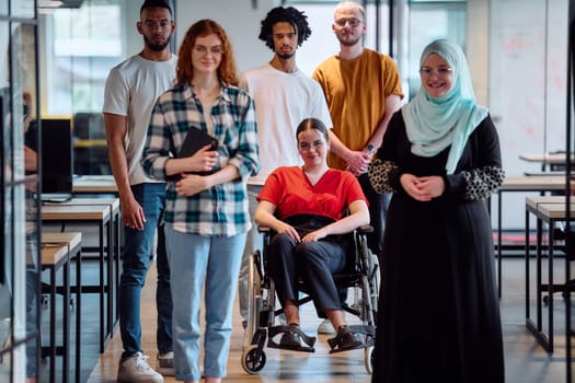 A diverse group of young business people walking a corridor in the glass-enclosed office of a modern startup, including a person in a wheelchair and a woman wearing a hijab.