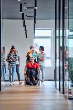 people walking a corridor in the glass-enclosed office of a modern startup, including a person in a wheelchair and a woman wearing a hijab.