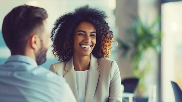 Happy two business people discussing a new project together in an office, professionals african smiling colleagues having a conversation at a meeting