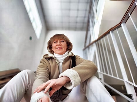 Cute girl on Indoor Staircase. Mature middle aged woman taking selfie indoors