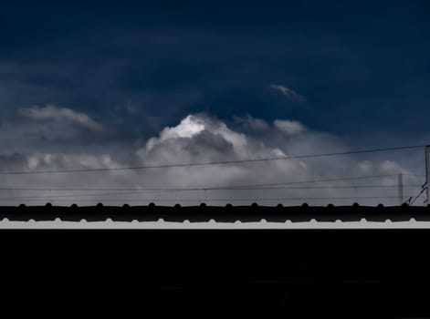 The black copy space under the metal roof and the cloud in the sky