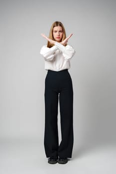 oung Woman Making X Sign With Arms to Express Prohibition or Disagreement in studio