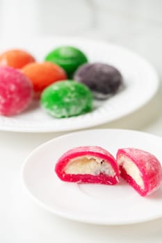 Multi-colored Japanese cakes Mochi in a white plate close up