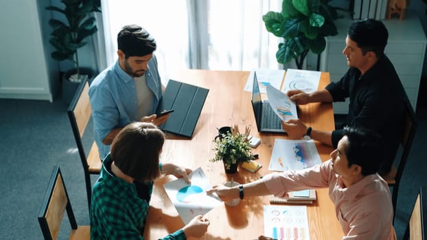 Top view of business people discuss idea while marketing team joining meeting. Manager pointing financial graph while colleagues talking to investor by using phone and brainstorm idea. Convocation.