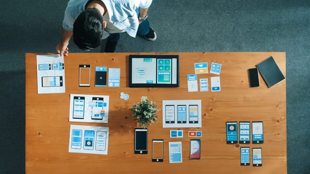 Top view of business man looking and choosing Ux Ui design at meeting room. Skilled developer designing and planning mobile phone interface or software application at creative workplace. Convocation.