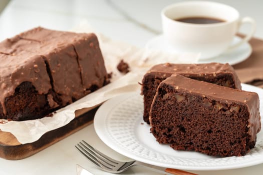 Fresh homemade chocolate sponge cake on wooden board close up