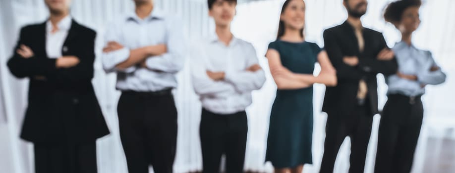 Panorama blurred group of businesspeople stand in line with cross arm gesture in modern corporate. Multiracial officer worker team bond and succeed together. Concord